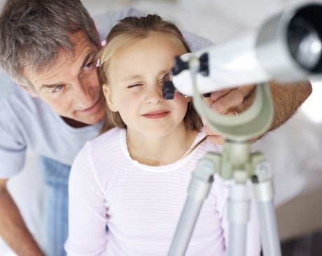 Vater sieht mit Tochter durch Fernrohr